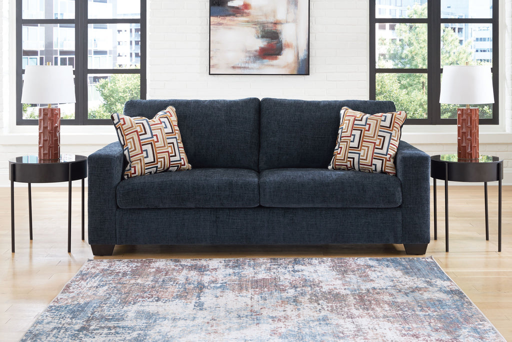 Navy blue sofa with two geometric throw pillows, squared arms and two-seat back