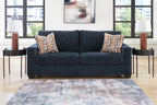 Navy blue sofa with two geometric throw pillows, squared arms and two-seat back