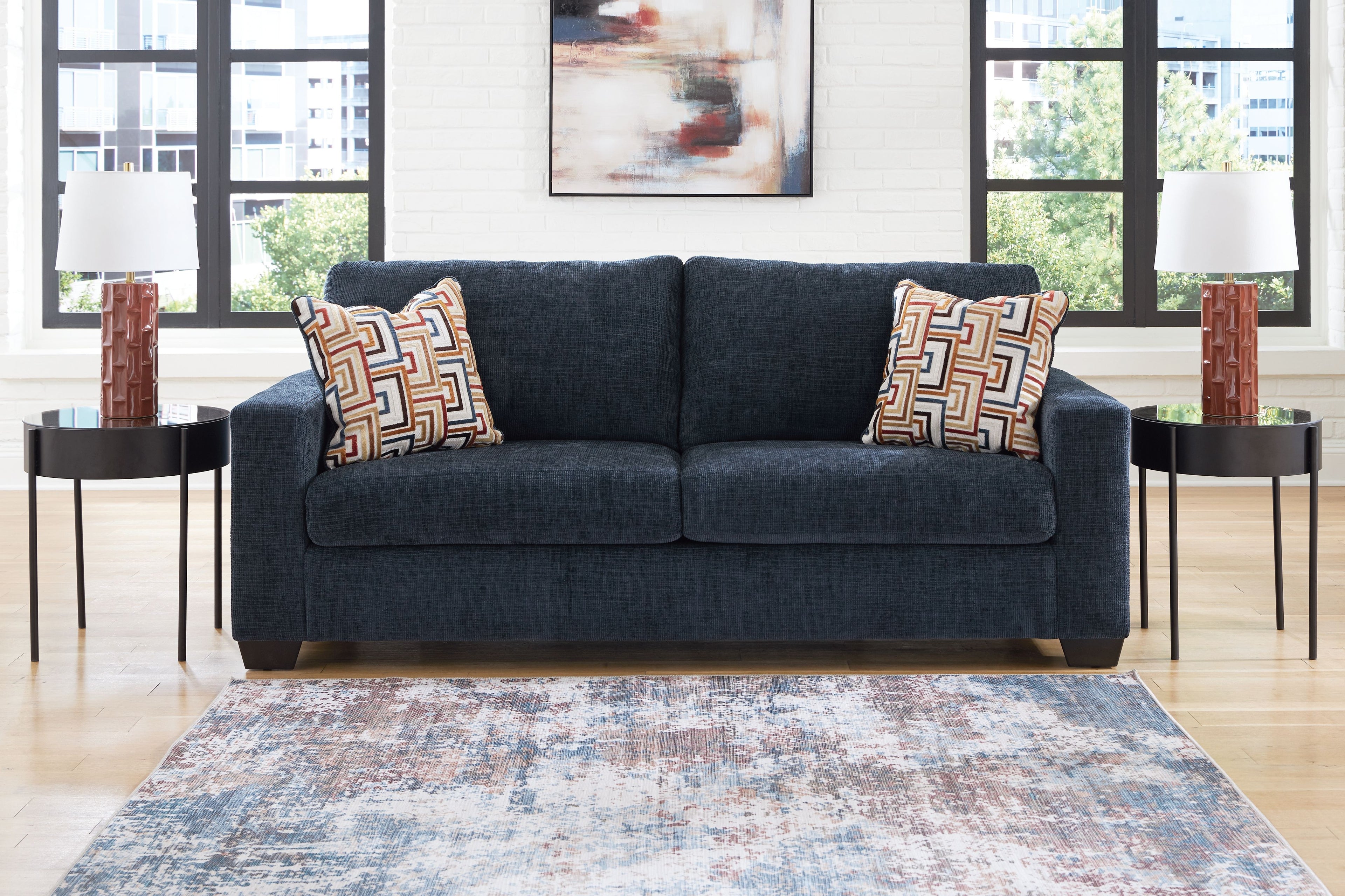 Navy blue sofa with two geometric throw pillows, squared arms and two-seat back