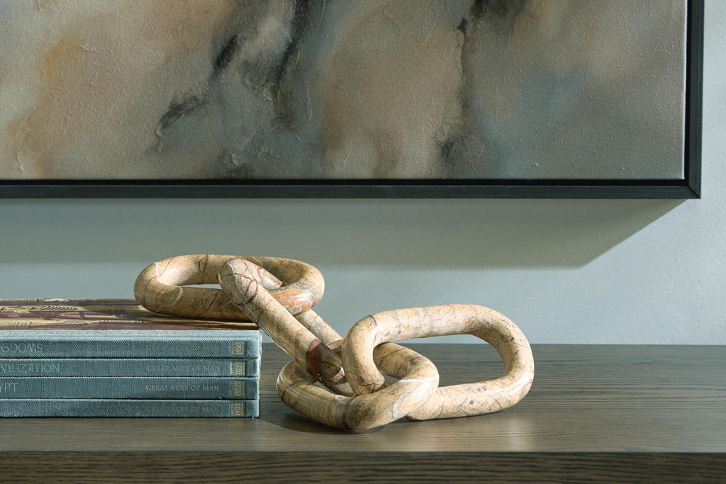 Light brown chain link sculpture with interlocked rings on a tabletop