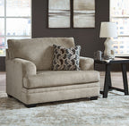 Light brown fabric accent chair with square arms and patterned throw pillow