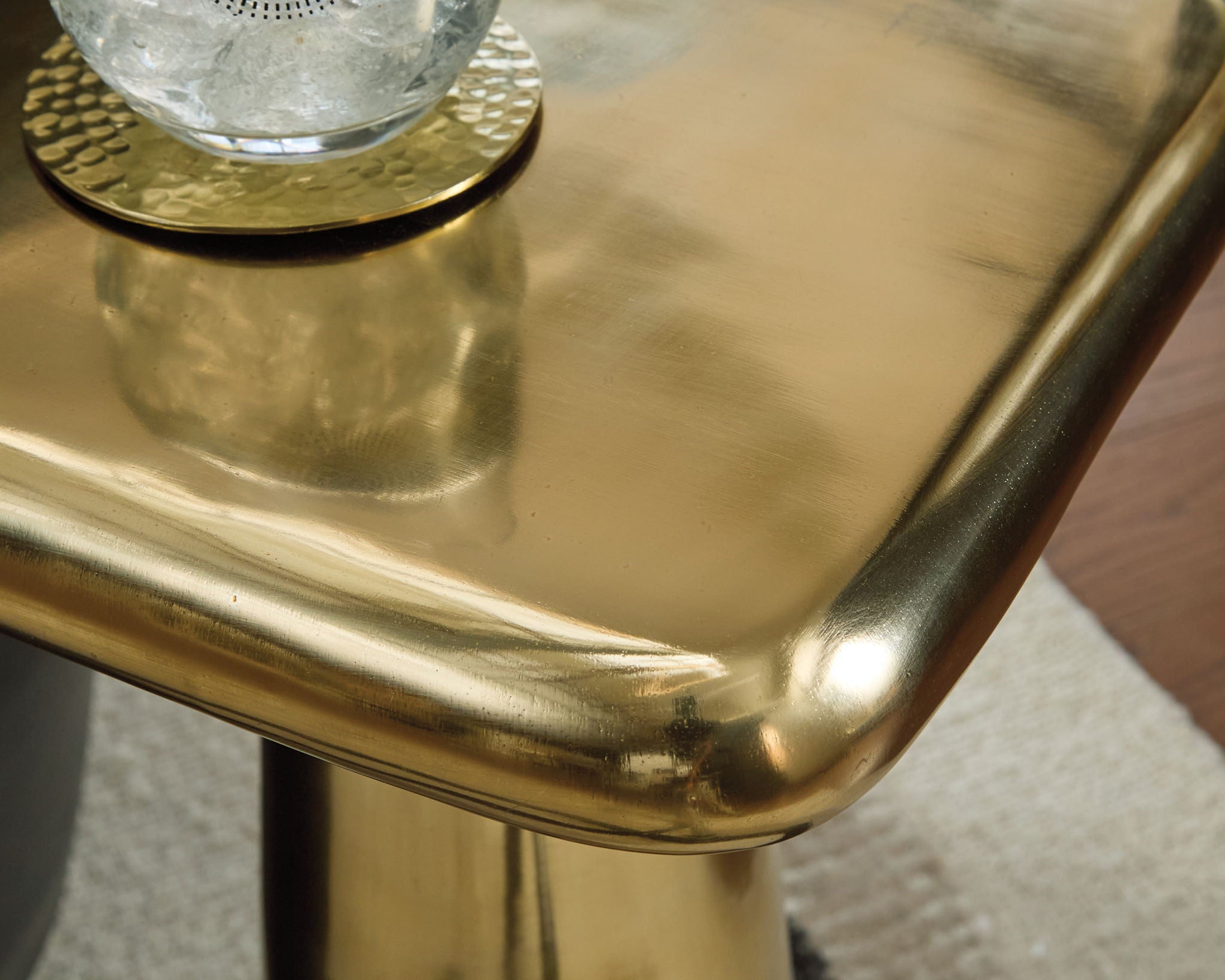 Gold accent table corner with rounded edge and smooth metallic finish
