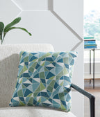Geometric blue and green decorative pillow on sofa seat