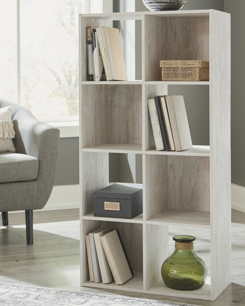 Whitewashed wood cube organizer with open cubbies and items for home storage