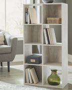 Whitewashed wood cube organizer with open cubbies and items for home storage