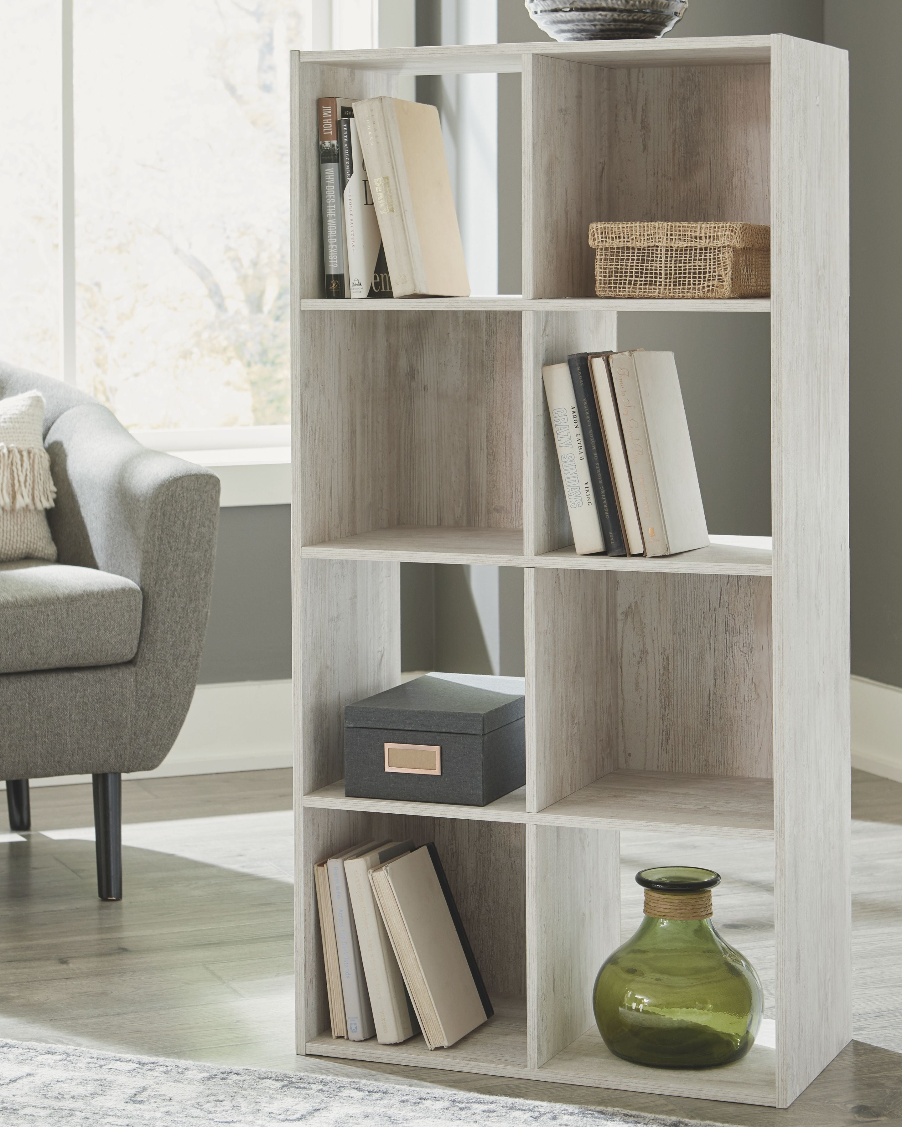 Whitewashed wood cube organizer with open cubbies and items for home storage