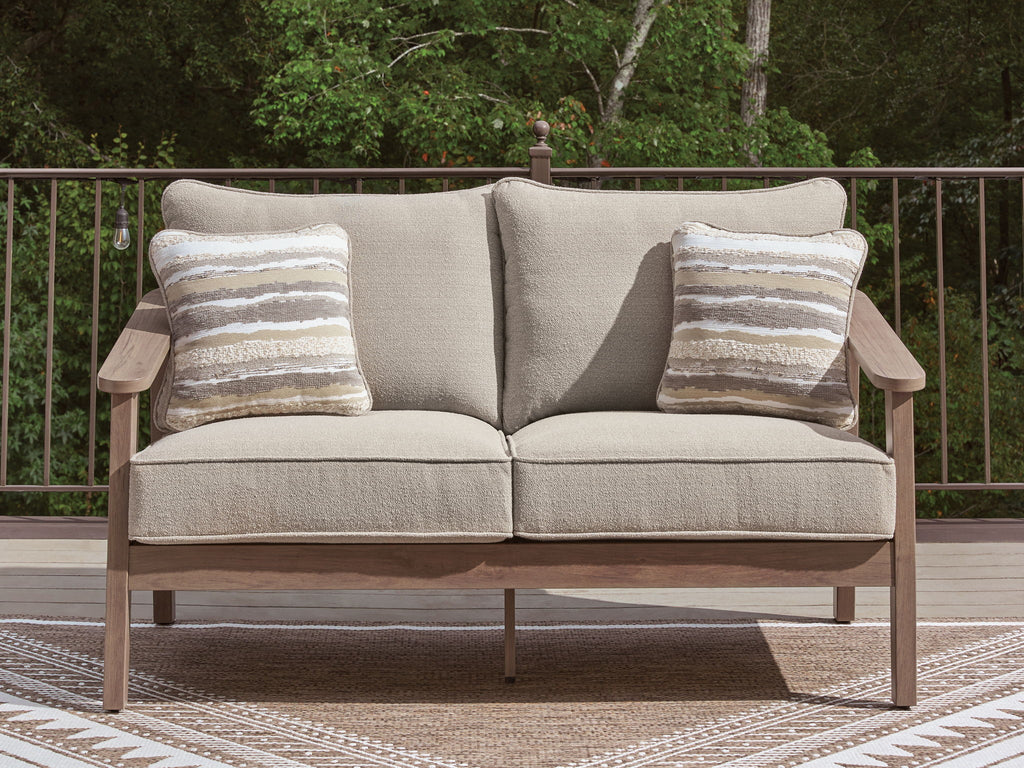 Beige loveseat with cushion and two striped pillows, wood arms