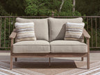 Beige loveseat with cushion and two striped pillows, wood arms