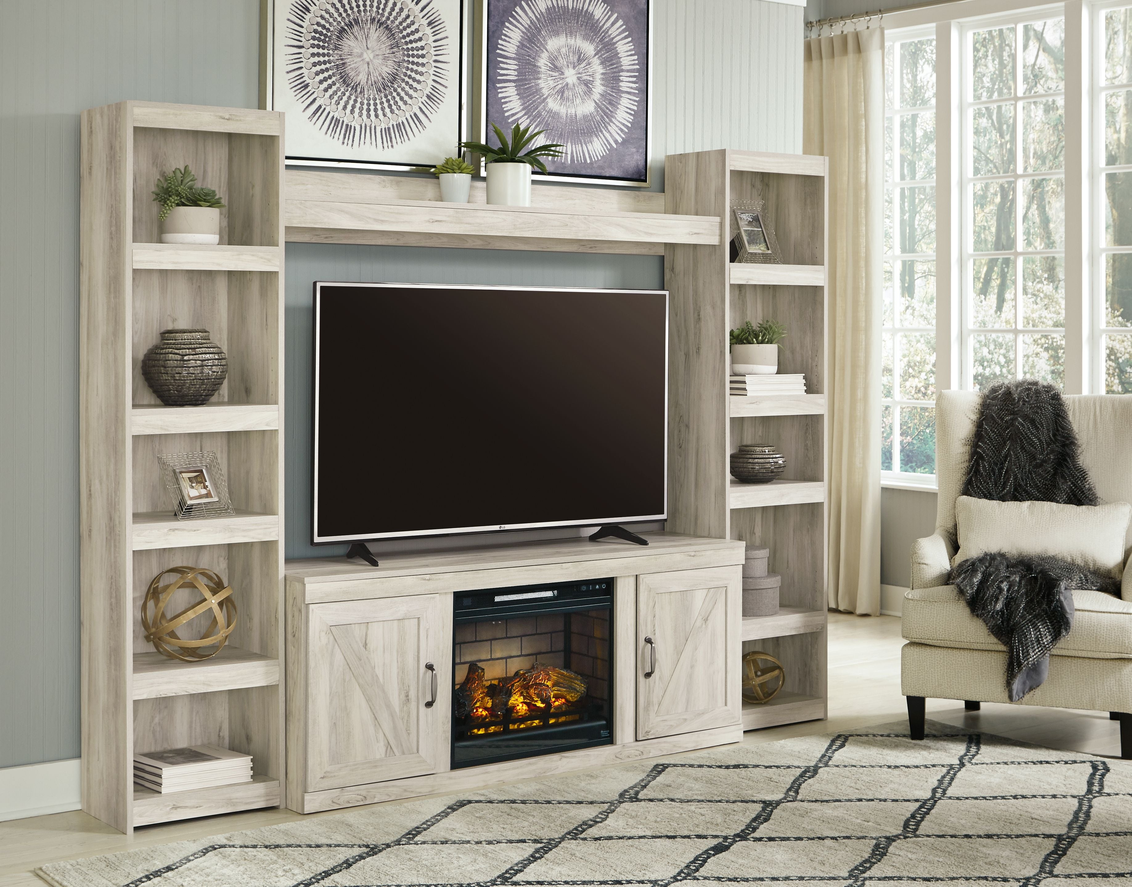 Beige entertainment center with open shelves, TV cabinet, and glowing electric fireplace