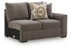 Gray fabric loveseat with two cushions and patterned square throw pillow; dark legs.