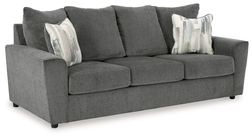 Dark gray fabric sofa with three seat cushions and five back pillows.