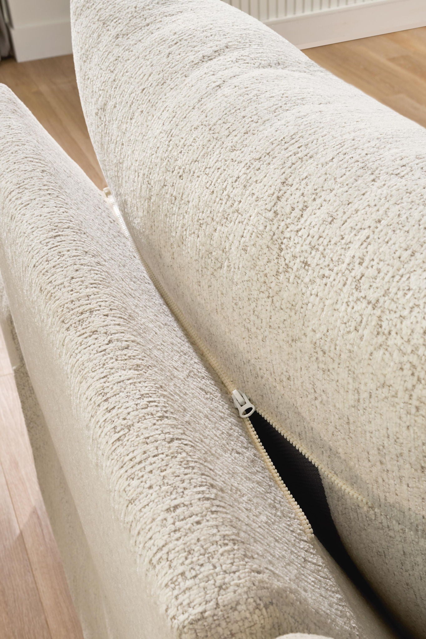 White textured fabric sectional cushion with visible zipper along the edge
