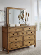Light brown wood dresser with mirror and drawer fronts with round knobs
