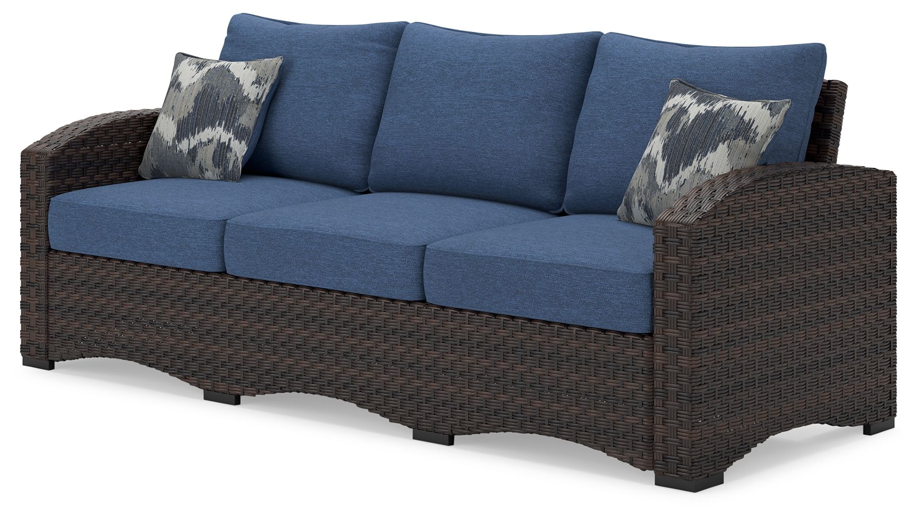 Outdoor sofa with blue cushions, brown wicker arms, two patterned throw pillows