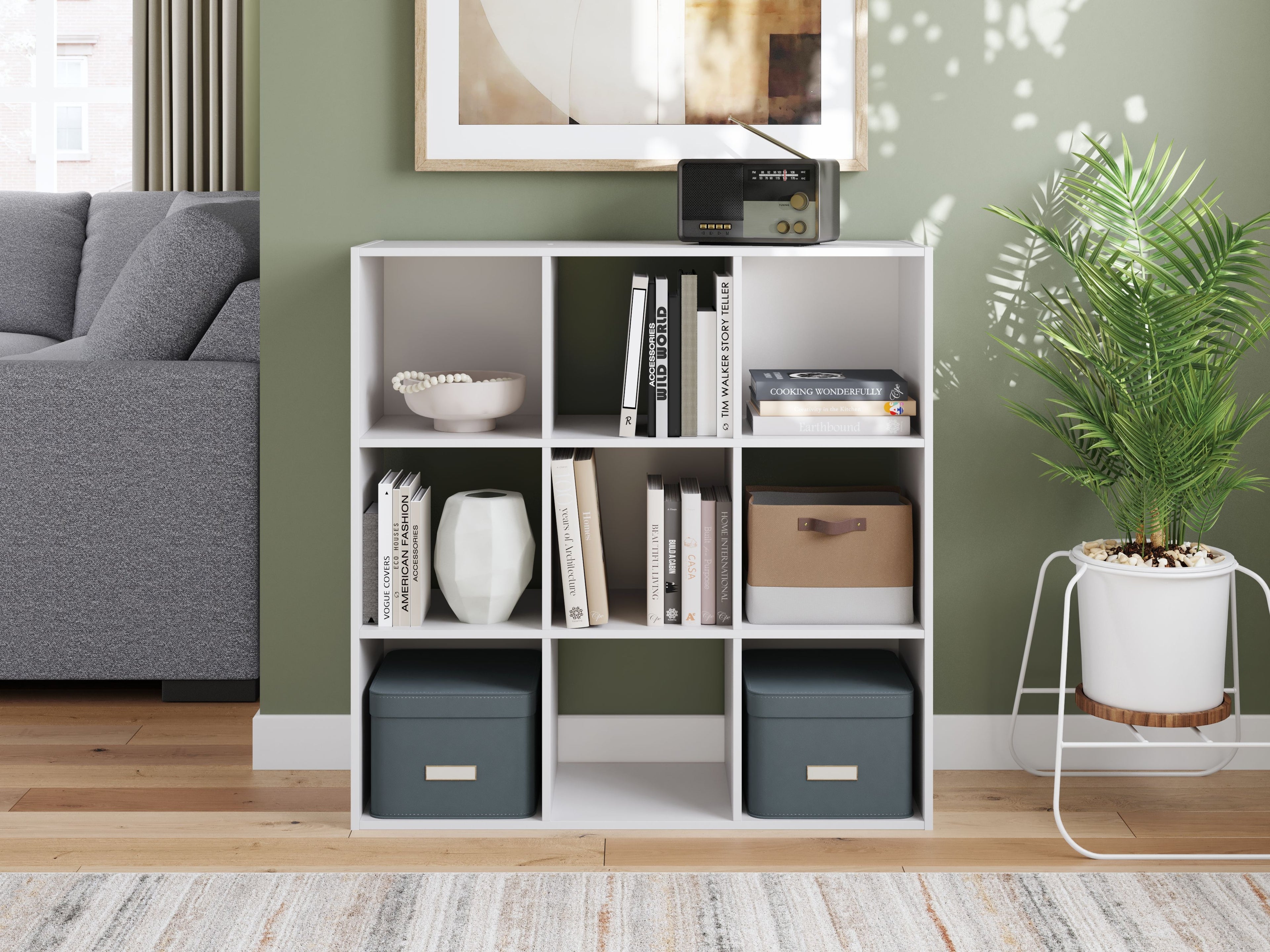 White cube organizer with 9 open cubbies, books and fabric bins displayed inside