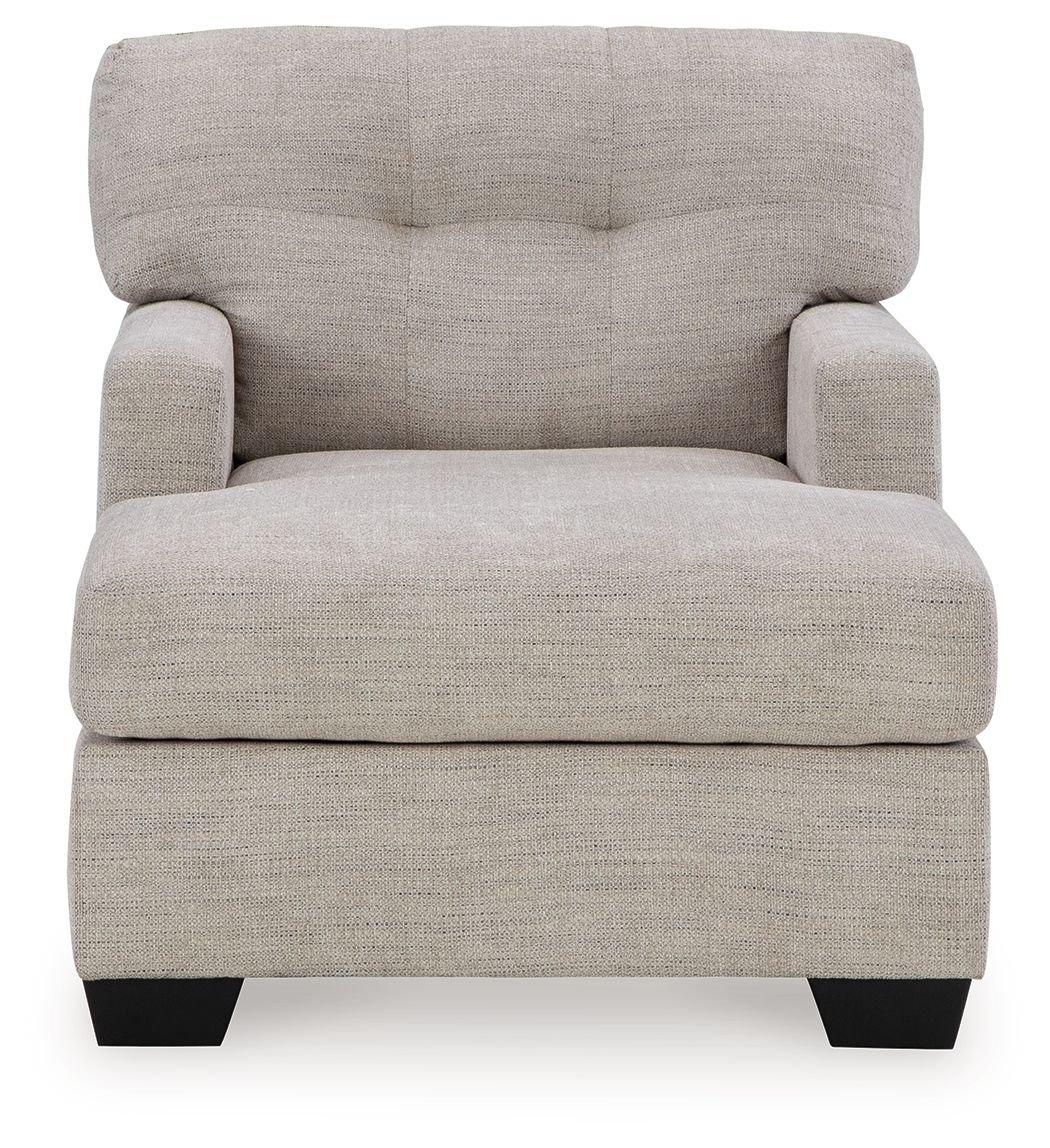 Pearl silver upholstered chaise chair with tufted back, cushioned seat, and black feet