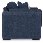 Blue upholstered chair with two striped accent pillows