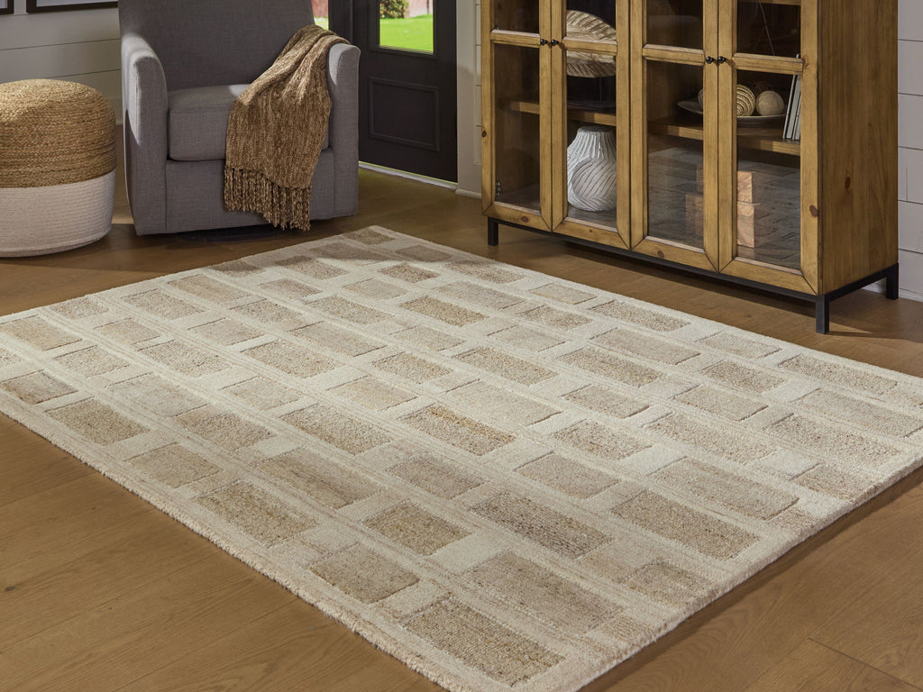 Beige geometric rug with repeating blocks, shown laid flat in living room