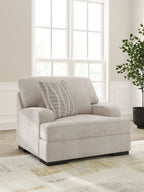 Taupe upholstered chair and a half with striped accent pillow in three-quarter view