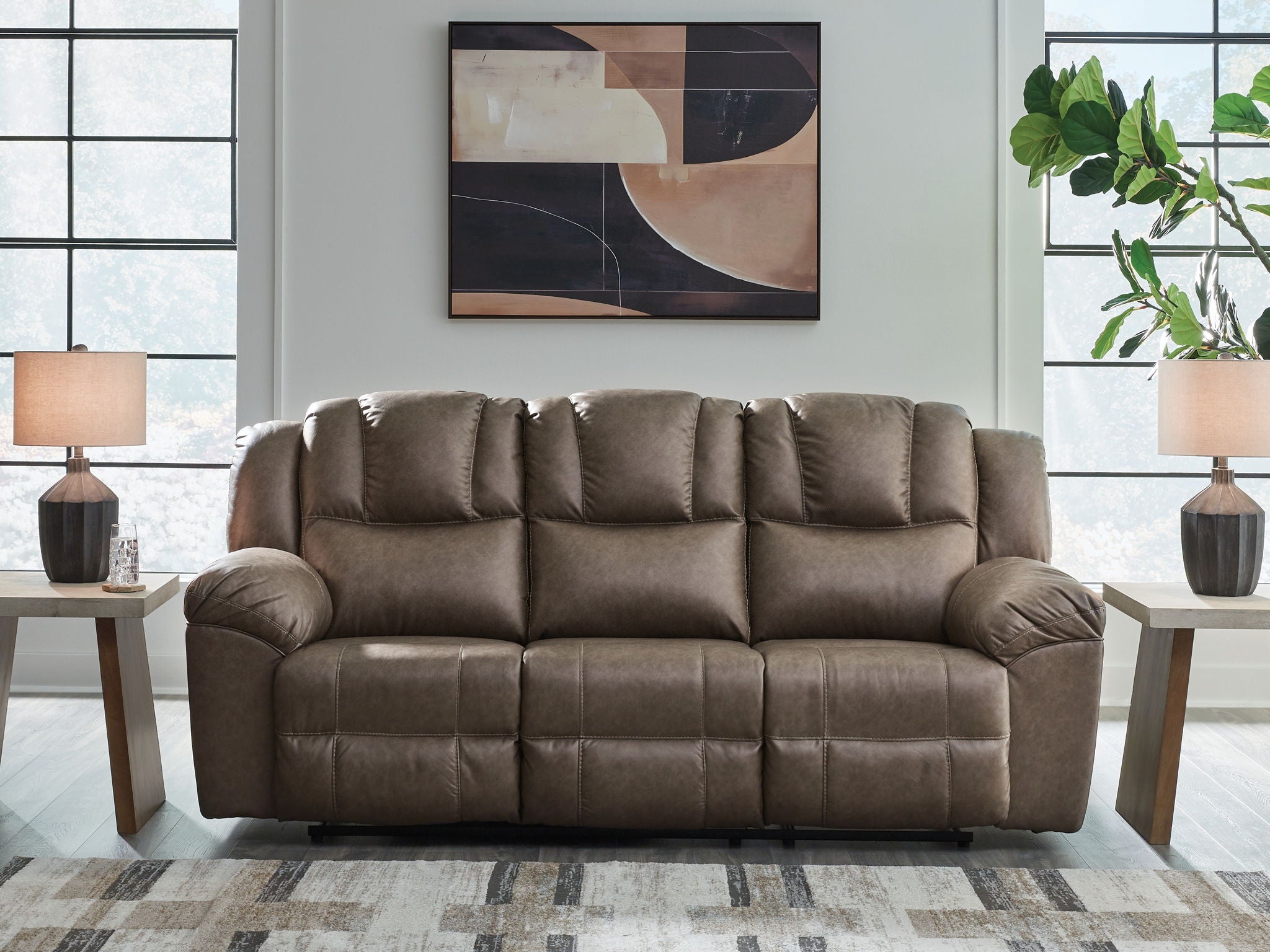 Driftwood-toned reclining sofa with tufted back and padded arms, three-seat cushions
