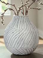 White vase with carved vertical stripes and branches in the opening