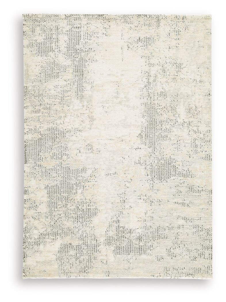 Cream area rug with scattered gray motifs and distressed, low-pile texture