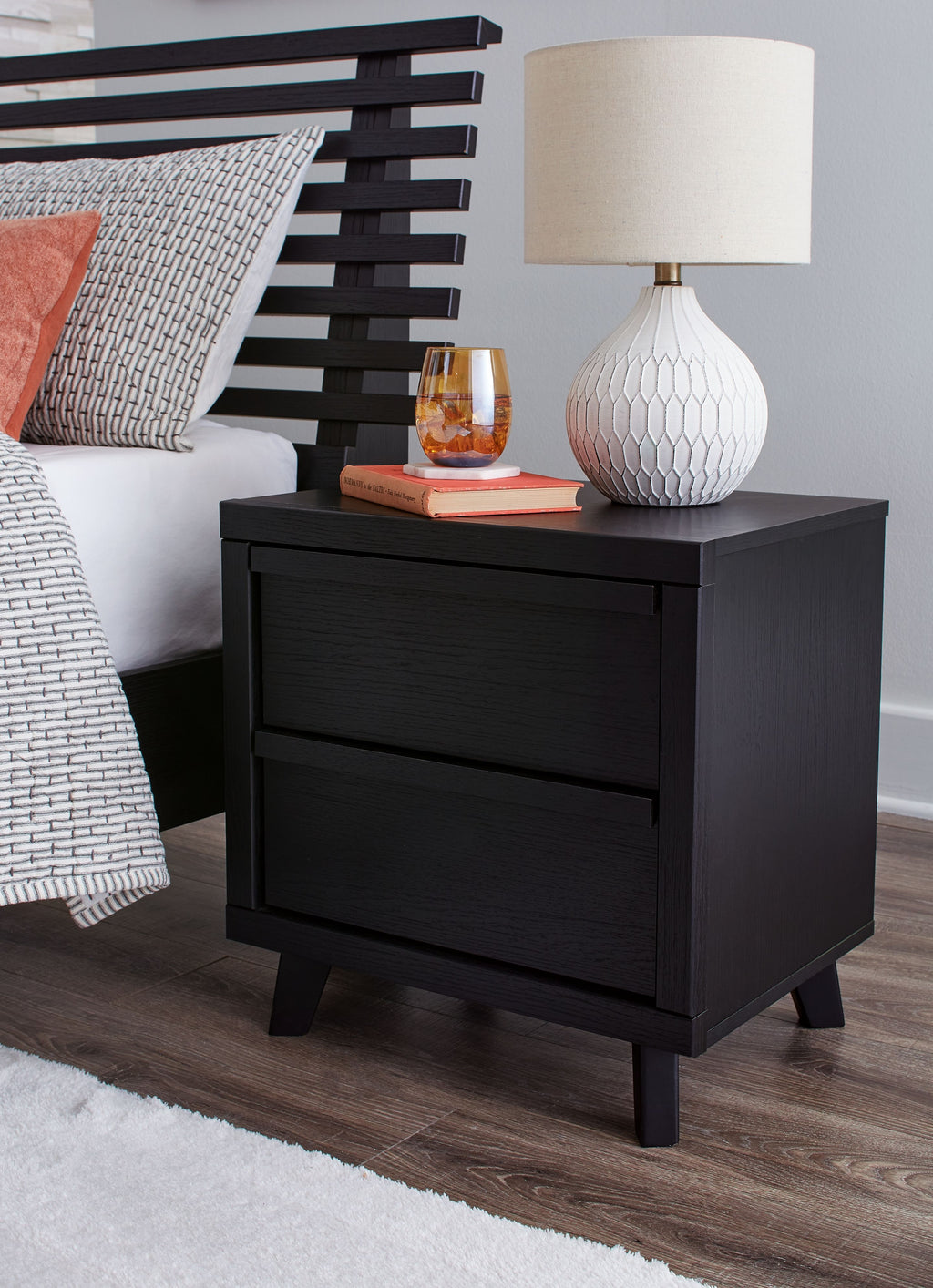 Black two-drawer night stand with flat top, centered drawers, and four dark legs