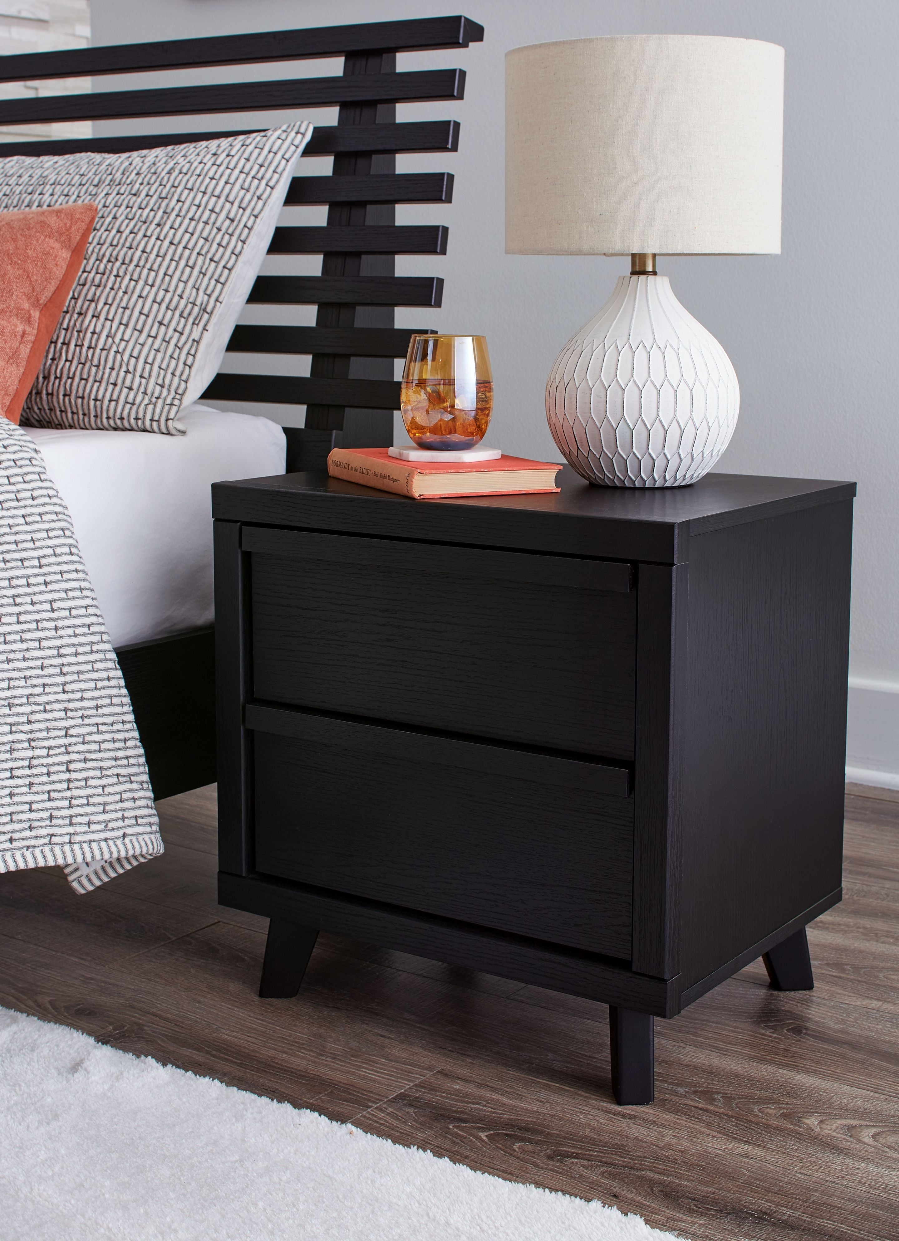 Black two-drawer night stand with flat top, centered drawers, and four dark legs