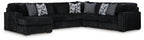 Black corded sectional sofa with chaise and gray patterned throw pillows