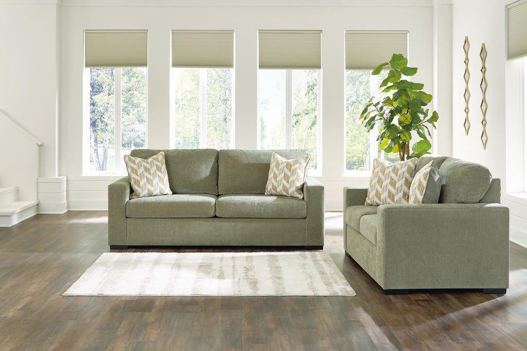 Living room set: green sofa and loveseat with beige patterned throw pillows