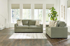 Living room set: green sofa and loveseat with beige patterned throw pillows