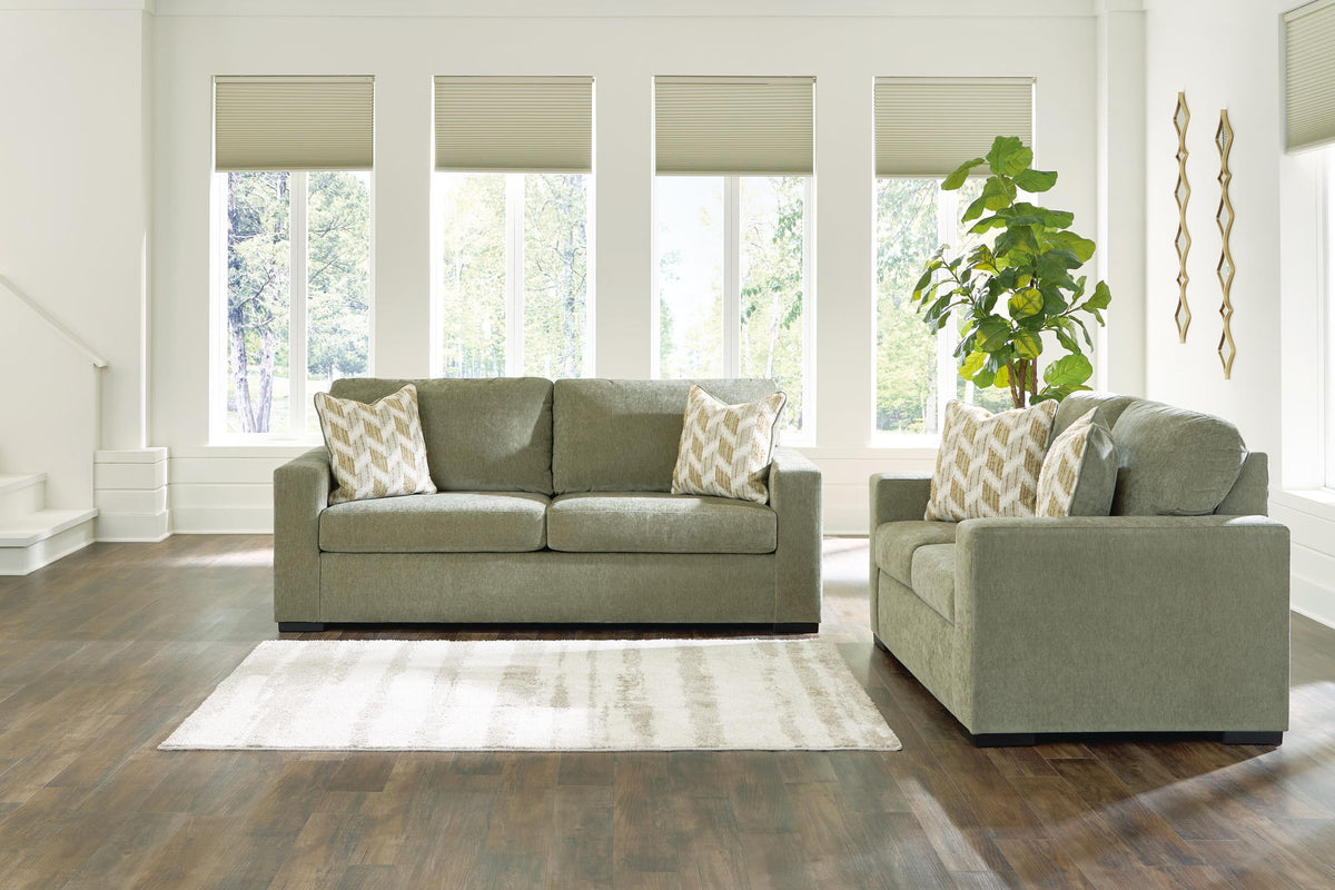 Living room set: green sofa and loveseat with beige patterned throw pillows