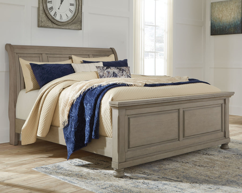 Lettner sleigh bed with two drawers, gray wood frame and blue-and-cream bedding