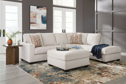 Light beige sectional sofa set with ottoman, chaise, and patterned throw pillows