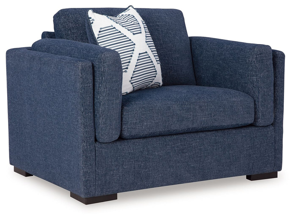 Blue upholstered chair with striped accent pillow and rolled arms
