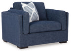 Blue upholstered chair with striped accent pillow and rolled arms