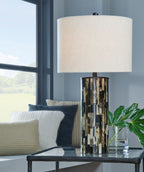 Table lamp with cream shade and cylindrical mosaic base on tabletop