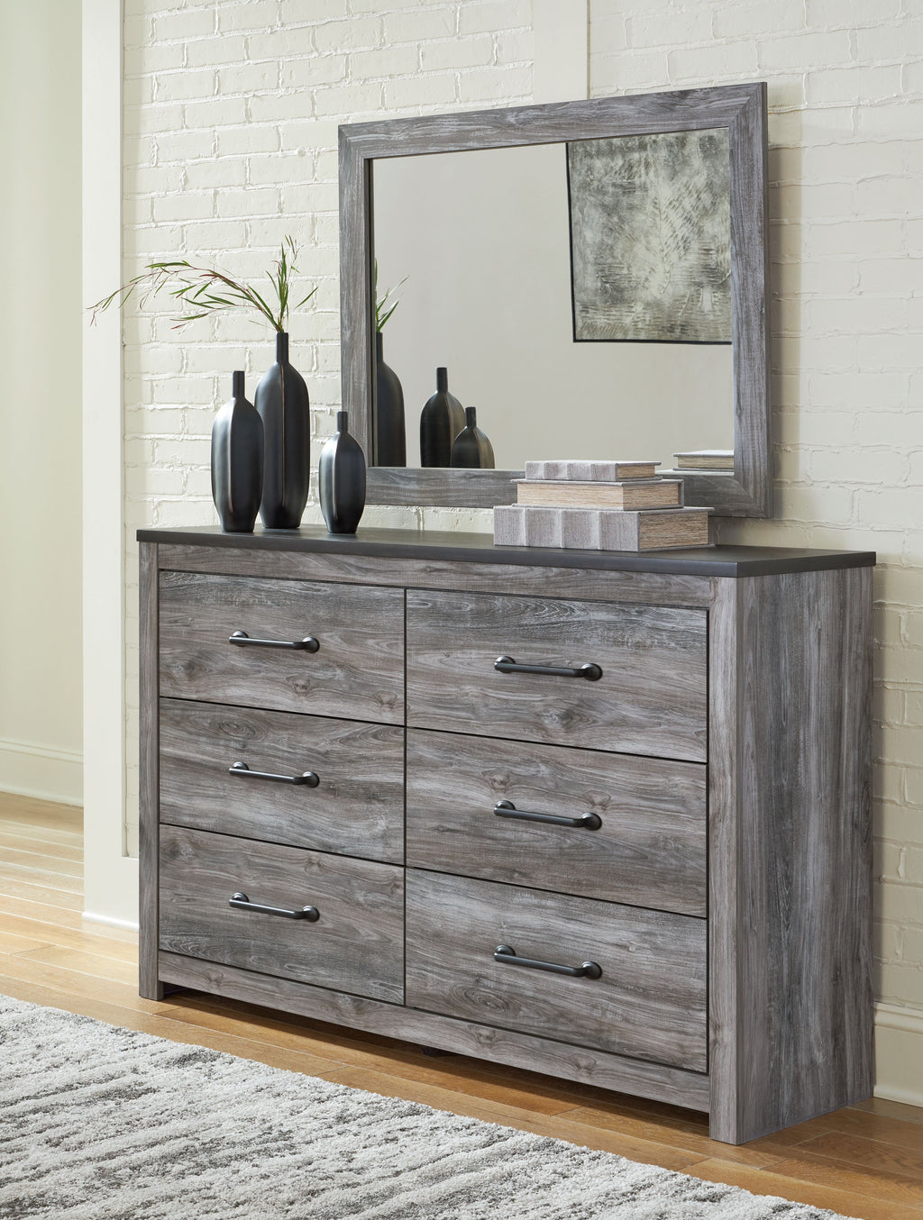 Dark gray dresser with four drawers and a matching wall mirror