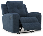 Ink blue fabric wall recliner with extended footrest, cushioned arms, and side button