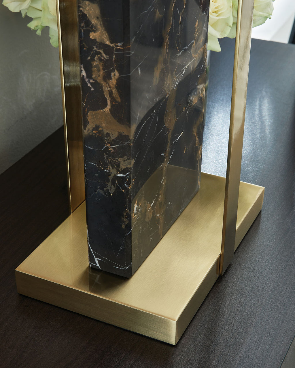 Black marble table lamp with gold base and frame, close-up of marble column