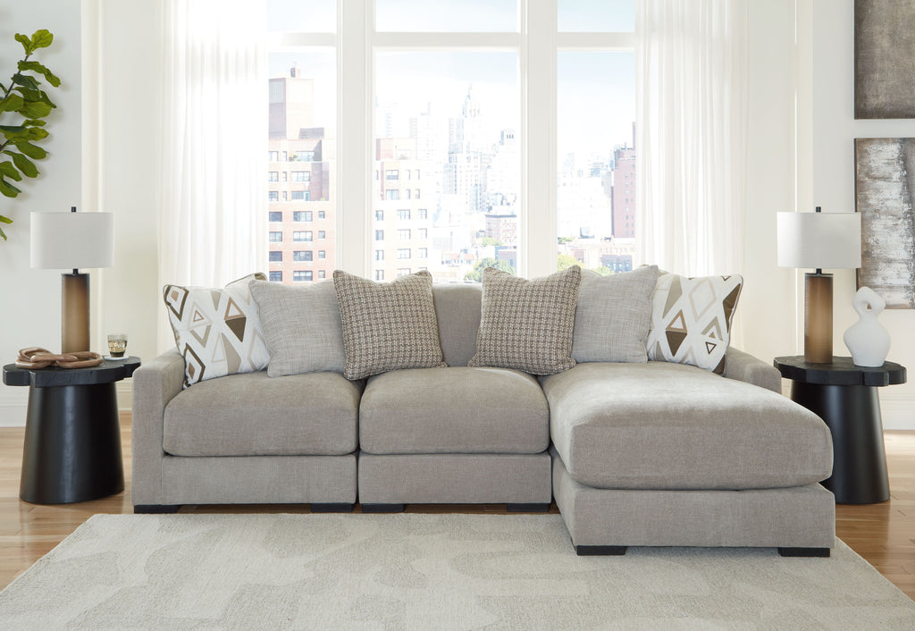 Light gray sofa sectional with ottoman-style chaise and geometric accent pillows