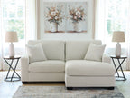 Light gray sofa chaise with four throw pillows and a chaise ottoman extension