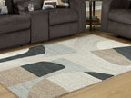 Abstract beige area rug with dark gray and light blue blocks and concentric wavy line pattern