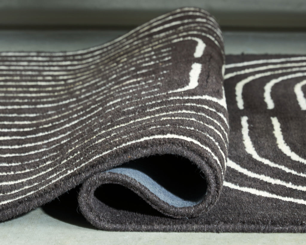 Eldonmore rug close-up: dark pile with white outline stripe pattern on edge.
