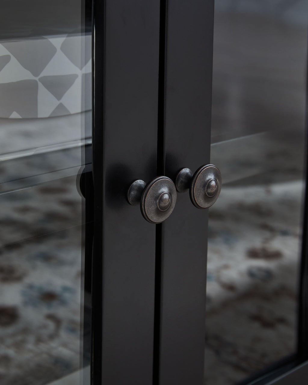 Black cabinet door with round metal knob handles