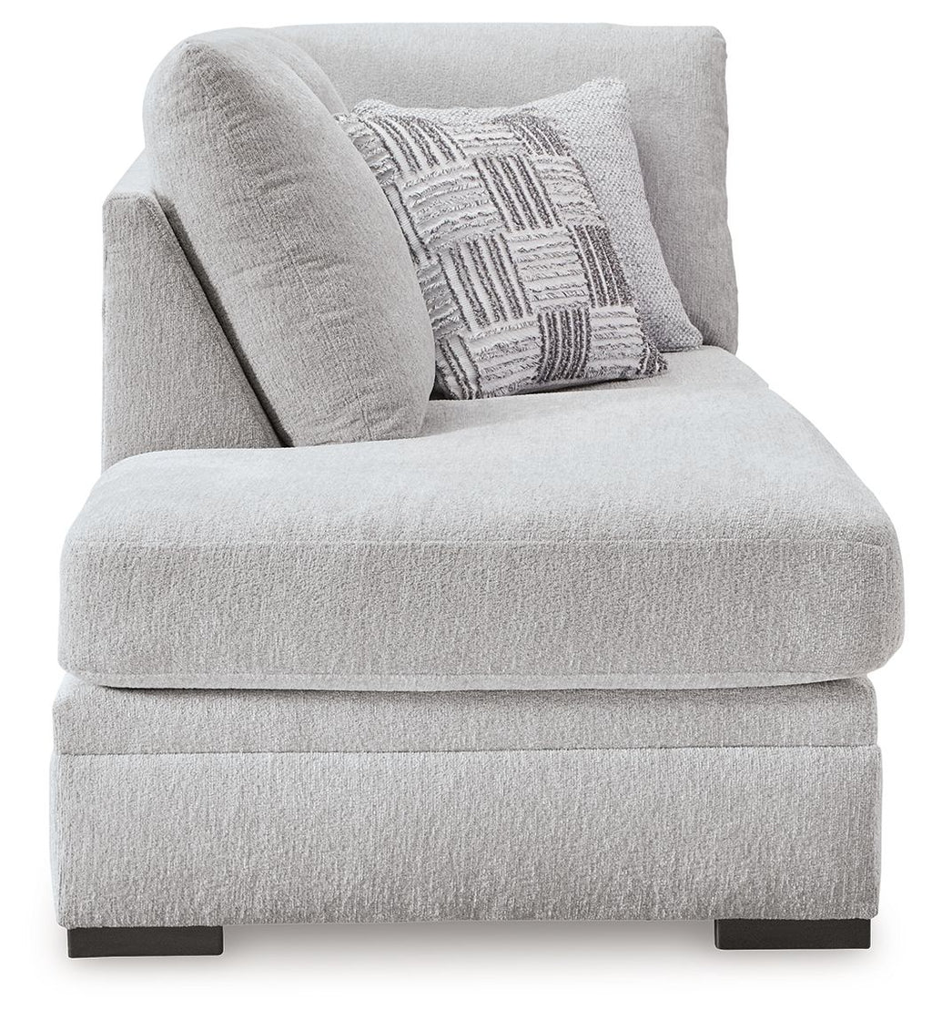 Corner chaise seat and back in light gray textured fabric with patterned throw pillow
