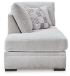 Corner chaise seat and back in light gray textured fabric with patterned throw pillow