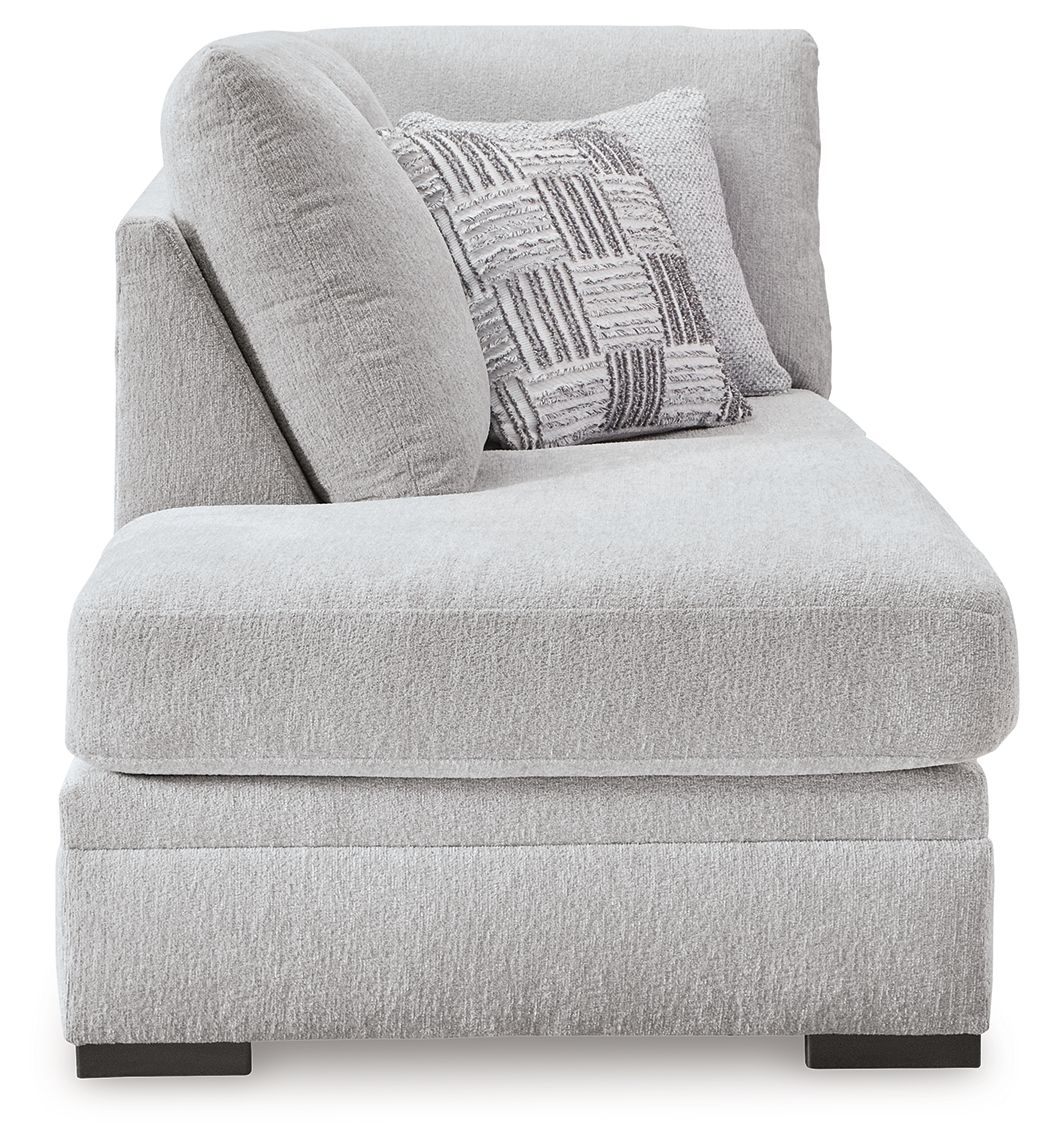 Corner chaise seat and back in light gray textured fabric with patterned throw pillow