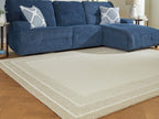 Beige area rug with wide border stripe and subtle nested rectangular design