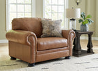Brown armchair and matching ottoman with patterned pillow on the chair